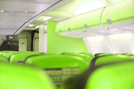 inside a airplane cabine with green seatsの写真素材