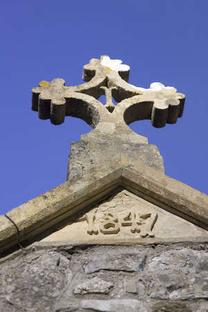 The Cross at stone on a old chapel roofの写真素材