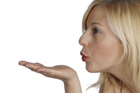 a young woman blow something from her handの写真素材