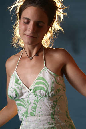 a voung woman is dancing with closed eyes in front of blue background