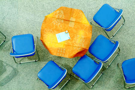 table with orange table cloth and blue chairの写真素材