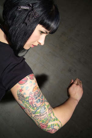 a woman with black hair and tattooed upper armの写真素材
