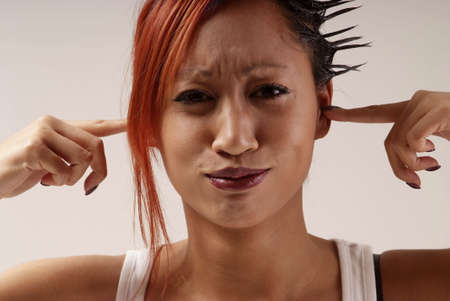 young woman put finger in her earsの写真素材