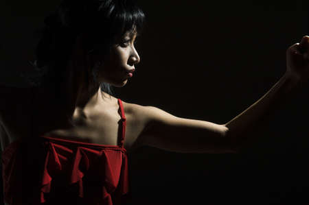 edgewise portrait of young woman black backgroundの写真素材