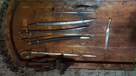 Medieval weapons on a wooden table in the old cellar of the castleの写真素材