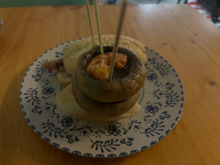 Baked champignon mushrooms stuffed with bacon and cheese on wooden tableの写真素材