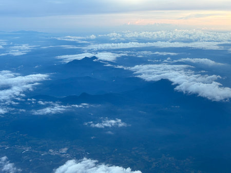 Aerial view of clouds and mountain in the blue sky at sunsetの写真素材
