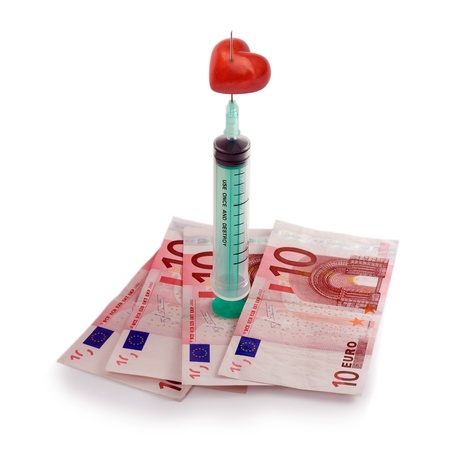 Needle and syringe with heart . Money Injection concepts isolated on white backgroundの写真素材