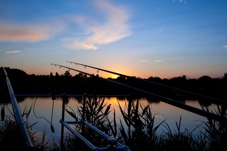 carp fishing sunrise - spinning on rod pod の写真素材
