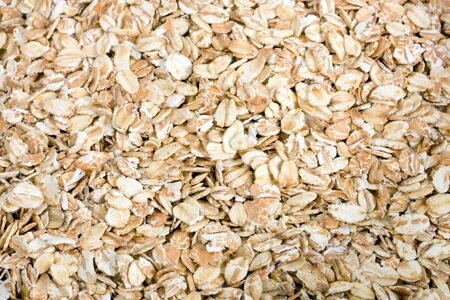 Pile of uncooked rolled oats - oatmeal background