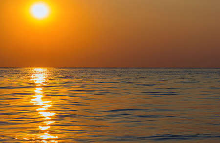 shows the sun setting over the sea の写真素材