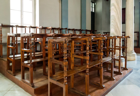 Rows of worn wooden chairs in a churchのeditorial素材