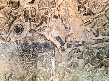 Khmer relief carving of gods fighting demons. Inner wall of the temple of Angkor Wat, Siem Reap,...