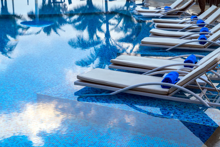 Sunbeds beside swimming pool のeditorial素材