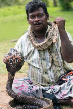 POLONNARUWA, SRI LANKA - JANUARY 31, 2016: Snake charmer adult man playing on musical instrument...