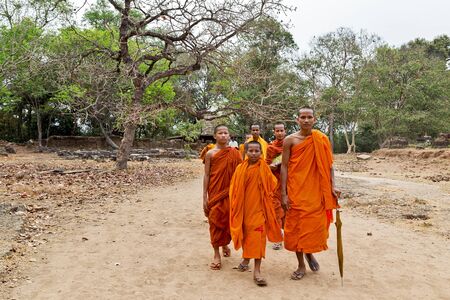 ANGKOR WAT, CAMBODIA - FEB 25, 2015 : Angkor Wat young Monk buddhist walking to jungle. Famous landmark, place of worship and popular tourist travel destination in Asia.のeditorial素材