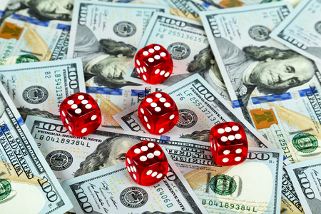 Casino red dices on gaming table US Dollar bills backgroundの写真素材