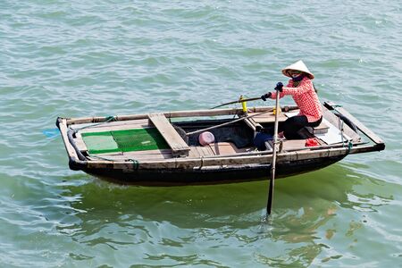 HA LONG, VIETNAM - November 28, 2014: Giirl paddle a bamboo boat most popular place Halong Bay in Vietnam. UNESCO World Heritage Site.のeditorial素材