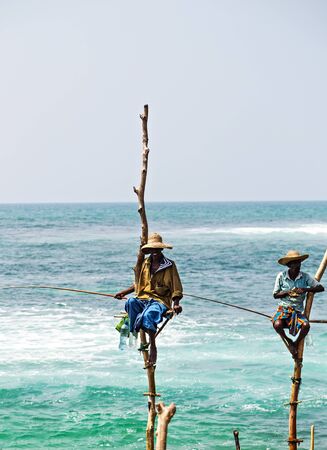 KOGGALA, Sri Lanka - February 09, 2016: Local traditional stilt fishermen fishing rod in Indian ocean, Sri Lanka.のeditorial素材
