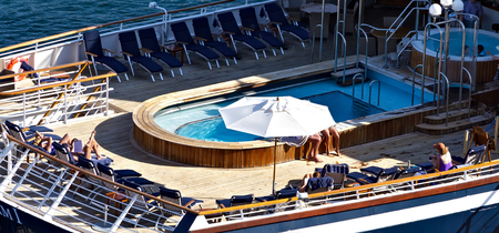 Sunbathers relaxing on the open deck cruise ship in the sea. Summer vacation Cruise travel tourism...