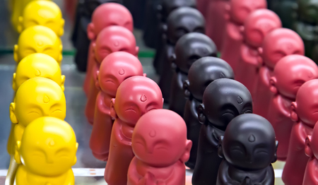 Buddha statue colorful toy figures of little budhist monks praying. Buddhist holiday - Happy Bodhi day achieved enlightenment.の写真素材
