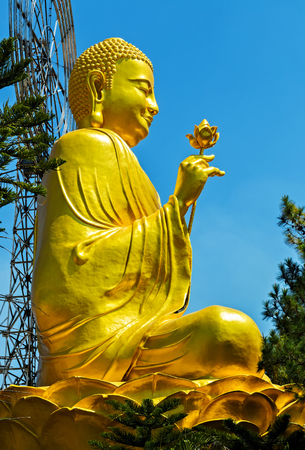 Buddha statue Meditating in buddhist temple sitting on blue sky. Buddhist holiday - Happy Bodhi day achieved enlightenment.の写真素材