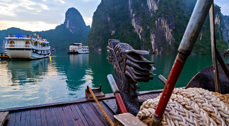 Tourist boat high cliff most popular landscape for travel Vietnam. Halong Bay Tour Dragon Cruise Discover Rock islands spectacular limestone.の写真素材