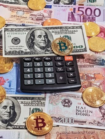 Gold bitcoin coin one hundred dollar bill Black electronic calculator Crypto Investing cryptocurrency exchange money background. Bitcoin to USDの写真素材