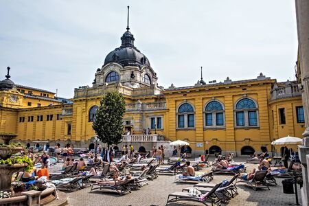 BUDAPEST, HUNGARY - August 24, 2019: Baroque-style domes mineral springs Szechenyi Spa people public. Enjoy the world-famous thermal spas in Budapest, Hungary.のeditorial素材