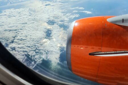 jet turbine airplane flying above clouds travel. Fly cruise transportation concept view from airplaneporthole window on the turbine.の写真素材