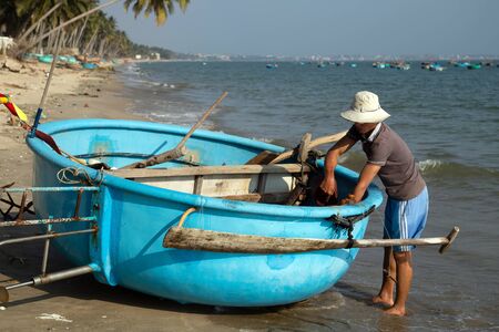 PHAN THIET, MUI NE, VIETNAM - Feb 16, 2015: Fisherman catch boats Vietnamese. People working at fishing pier in fishing village Phan Thiet, Travel Southeast Asia Coast Binh Thuan of Vietnam.のeditorial素材