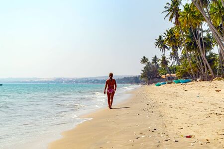 PHAN THIET, VIETNAM - Feb 16, 2015: Vietnamese Girl vietnam hat Slow life. People tropical beach with coconut palm trees, Phan Thiet. Travel Southeast Asia Coast Binh Thuan of Vietnam.のeditorial素材