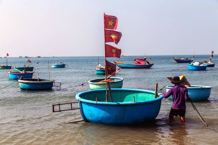 PHAN THIET, MUI NE, VIETNAM - Feb 16, 2015: Fisherman catch boats Vietnamese. People working at fishing pier in fishing village Phan Thiet, Travel Southeast Asia Coast Binh Thuan of Vietnam.のeditorial素材