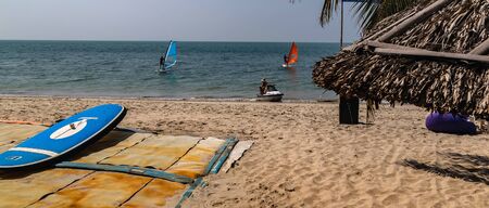 PHAN THIET, VIETNAM - Feb 16, 2015: Girl pretty, People tropical beach with coconut palm trees, Phan Thiet. Sunbed woman tanned body bikini sunbathing on deck chair, relaxing on beach chair.のeditorial素材