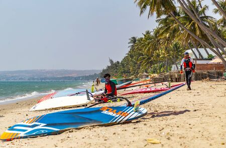 Mui Ne, Phan Thiet, Vietnam - Feb 16, 2015: Windsurfing surface water sport combines elements of surfing and sailing. Mui Ne Coco Beach sand, palm trees. Tourists vacation Cam Ranh Bay in Vietnam.のeditorial素材