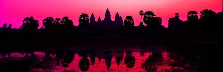 Beautiful colorful sunrise Wat facade Palm trees silhouette - Cambodia World famous buildings. Angkor Archaeological Park near Siem Reap in Cambodiaの写真素材