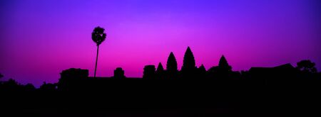 Panorama Mist sunrise tropical morning violet tourist attraction ancient temple facade silhouette of the Angkor Wat temple in Angkor Archaeological Park near Siem Reap in Cambodia.の写真素材