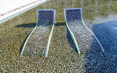 tropical resort hotel with swimming pool. Beach chair tile floor marble ceramic mosaic. Vacation and...
