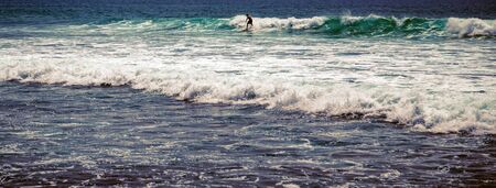 Surfer man on Blue Ocean Wave Bali Indonesia water sport lessons swimming activity riding wavesの写真素材