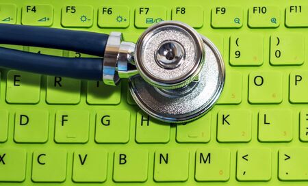 Sprague Rappaport Stethoscope health care closeup shot keyboard keys desktop top view green background ecology service conceptの写真素材