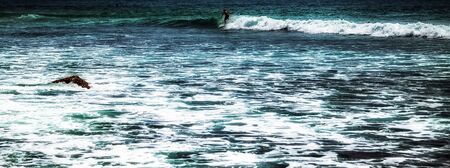 Surfer on a surfboard in the sea water splash blue transparent surf fresh ocean water background island of Bali Indonesia.の写真素材