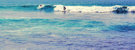Surfer surfboard Surfing standing ocean wave Bodyboarding water sport. Bali Surf Zone Surfer Riding...