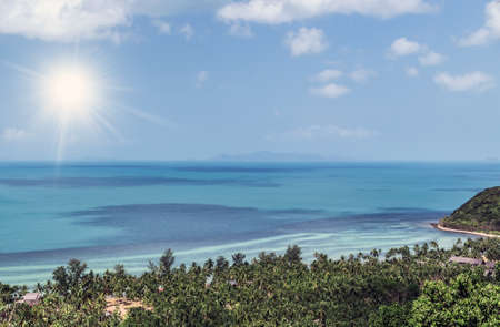 Rocky beach island with green tree forest top view sea surf backgroundの写真素材