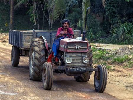 Old farmer on agricultural vintage farming tractor. Kandy Sri Lanka - February 07, 2016.のeditorial素材