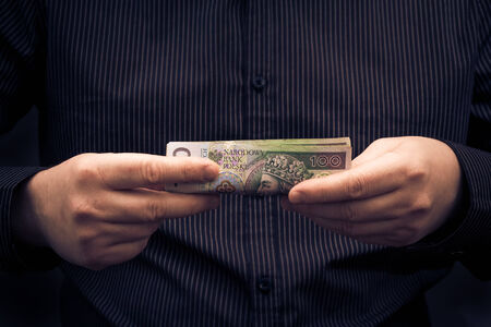 A man holds in the hands of Polish moneyの写真素材