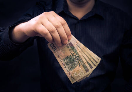 A man holds in the hands of Polish moneyの写真素材