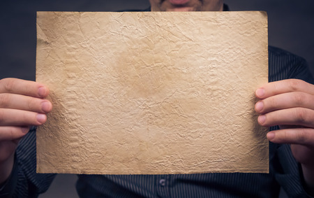 Old sheet of paper in his hands horizontallyの写真素材