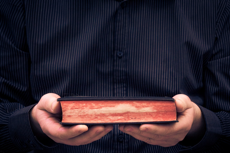 A man holds in the hands of an old book