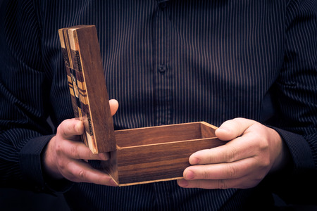 Open an old box in the hands of a manの写真素材