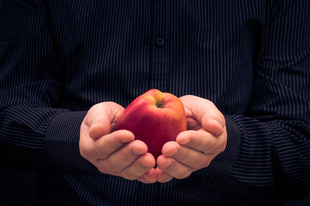 Red apple in the hands of manの写真素材